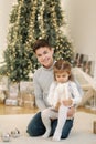 Happy young boy with his niece play in front of fir tree. Christmas mood Royalty Free Stock Photo