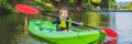 Happy young boy holding paddle in a kayak on the river, enjoying a lovely summer day BANNER, LONG FORMAT Royalty Free Stock Photo