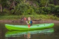 Happy young boy holding paddle in a kayak on the river, enjoying a lovely summer day Royalty Free Stock Photo