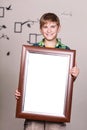 Happy young boy holding portrait frame