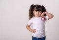 Happy child holding red clock on grey background. Kid with alarm clock