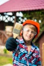 Happy young boy kid ready to paint the dog house with paint brush Royalty Free Stock Photo