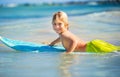 Happy young boy in the ocean on surfboard Royalty Free Stock Photo