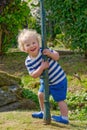 Happy young boy with playful smile in garden during summer sunshine Royalty Free Stock Photo