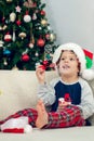 Happy boy playing with a Christmas tree in the background Royalty Free Stock Photo