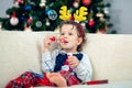 Happy boy playing with a Christmas tree in the background Royalty Free Stock Photo