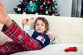 Happy boy playing with a Christmas tree in the background Royalty Free Stock Photo