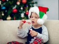 Happy boy playing with a Christmas tree in the background Royalty Free Stock Photo