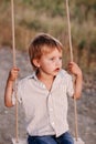 Happy young boy playing on swing in a park Royalty Free Stock Photo