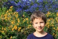 A happy young boy portrait outdoor in the spring garden. Children gardening design. Floral background