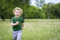 Happy young boy running through the grass