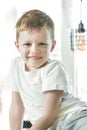 Happy young boy with smile on his face in bright interior Royalty Free Stock Photo