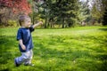 Happy Young Boy Walking in a Park Holding Out a Dandelion Flower Royalty Free Stock Photo