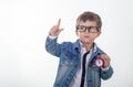 Happy young boy in white t-shirt and jeans jacket thinking and looking up with red clock pointing finger up on white background. Royalty Free Stock Photo