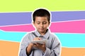 Happy young boy writing on tablet with colourful background.