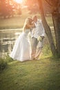 Happy young bridal couple kissing under tree Royalty Free Stock Photo