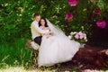 Happy young bride and groom in a pink decorated with peonies area in nature, family, relationships, romance, smiles, hugs, love Royalty Free Stock Photo