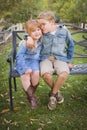 Happy Young Brother and Sister Sitting Together Outside Royalty Free Stock Photo