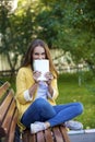 Happy young brunette sitting on a park bench Royalty Free Stock Photo