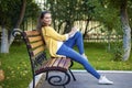 Happy young brunette sitting on a park bench Royalty Free Stock Photo