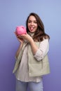 happy young brunette woman holding pink piggy bank money Royalty Free Stock Photo