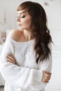 Happy young brunette woman with perfect slim body in warm cozy sweater dreaming, looking down. Cozy winter portrait of Royalty Free Stock Photo