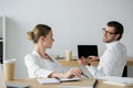 happy young business colleagues chatting at workplace Royalty Free Stock Photo