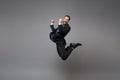 Happy young business man in classic black suit shirt tie posing isolated on grey background. Achievement career wealth