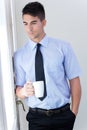 Happy young business man relaxing with coffee cup in modern off Royalty Free Stock Photo