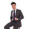 Happy young business man sitting on a chair and smiles Royalty Free Stock Photo