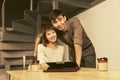 Happy young couple using digital tablet computer sitting at the table Royalty Free Stock Photo