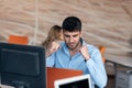 Happy young business man working on desktop computer at his desk in modern bright startup office interior Royalty Free Stock Photo