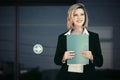 Happy young business woman with a folder against office building Royalty Free Stock Photo