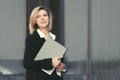 Happy young business woman with a folder at office building Royalty Free Stock Photo