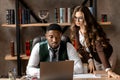 Happy young business woman and handsome african man working together using laptop in the office Royalty Free Stock Photo