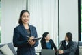 Happy young business woman with her staff, people group in background at modern bright office indoors Royalty Free Stock Photo