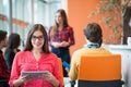 Happy young business woman with her staff, people group in background at modern bright office indoors Royalty Free Stock Photo