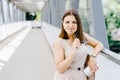 Happy young business woman holding mobile phone while walking on the street Royalty Free Stock Photo