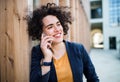 A happy young business woman with smartphone standing outdoors. Royalty Free Stock Photo