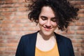 A happy young business woman standing outdoors, brick wall in the background. Royalty Free Stock Photo