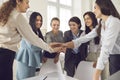 Happy young business women or company workers putting hands together in team meeting Royalty Free Stock Photo