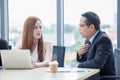 happy young businessman and businesswoman team working together with laptop computer on desk discussing information in office.boss Royalty Free Stock Photo