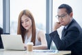 happy young businessman and businesswoman team working together with laptop computer on desk discussing information in office.boss Royalty Free Stock Photo