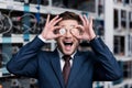 happy young businessman covering eyes with bitcoins at cryptocurrency