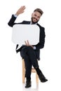 Happy young businessman holding speech bubble and laughing Royalty Free Stock Photo