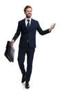 Happy young businessman holding suitcase and presenting to side Royalty Free Stock Photo