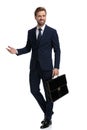 Happy young businessman holding suitcase and smiling Royalty Free Stock Photo