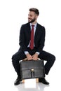 Happy young businessman holding suitcase and smiling Royalty Free Stock Photo