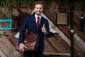 Happy young businessman holding suitcase and smiling Royalty Free Stock Photo