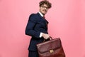 Happy young businessman holding suitcase and walking Royalty Free Stock Photo